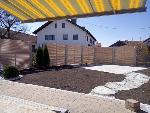 Garten mit Weg aus Naturstein, Steinterrasse und Sichtschutzzaun aus Holzlatten