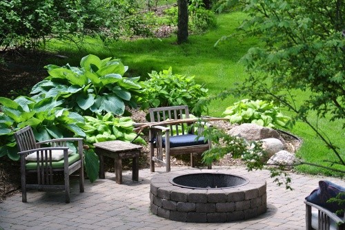Natursteinpflaster-Terrasse mit eingelassener Feuerstelle