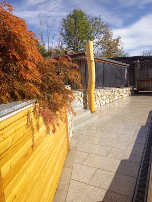 Natürliche Terrassengestaltung mit Elementen aus Holz und Naturstein